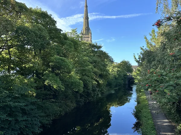 River scene with church spire and green trees